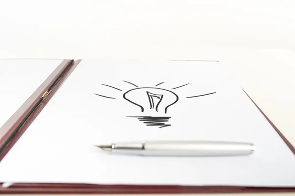 Penna på papper med glödlampa ritning — Stockfoto