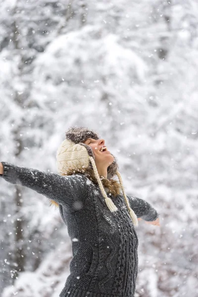 Mujer feliz en la caída de nieve con los brazos abiertos —  Fotos de Stock