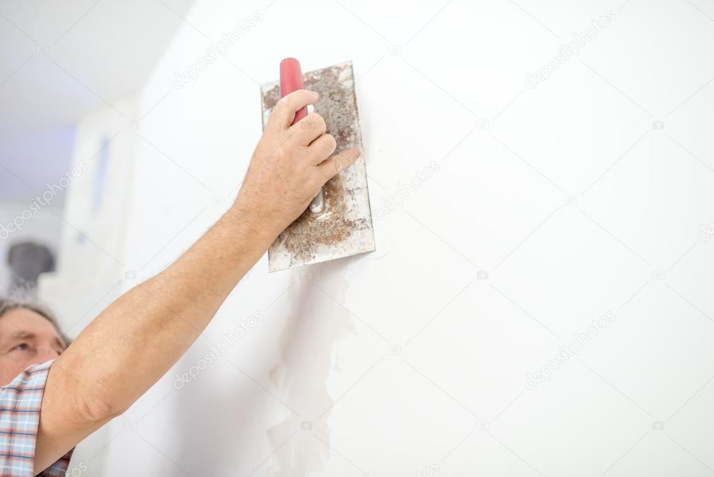 Man plastering a white wall