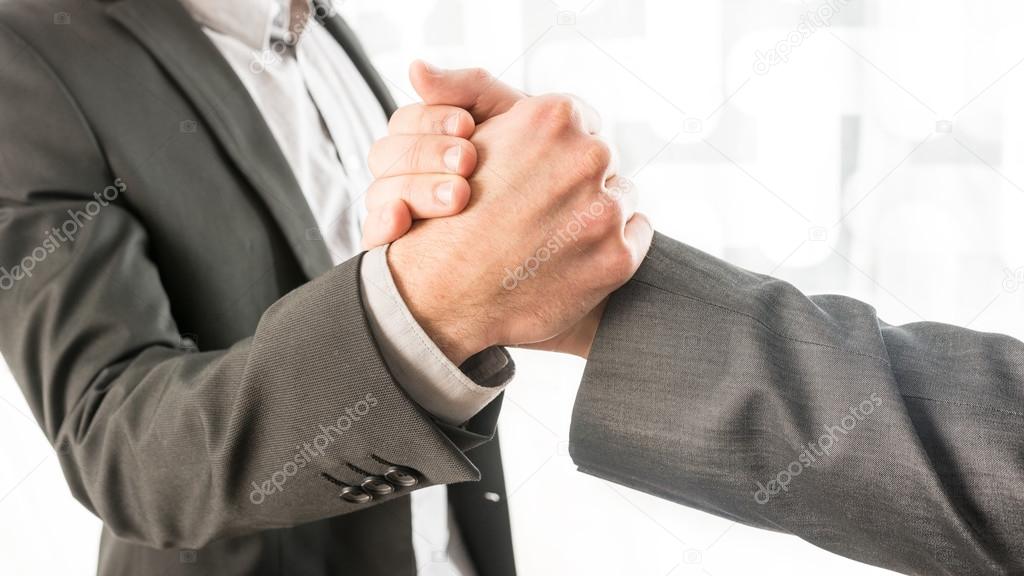 Conceptual Businessmen Gripping Their Hands