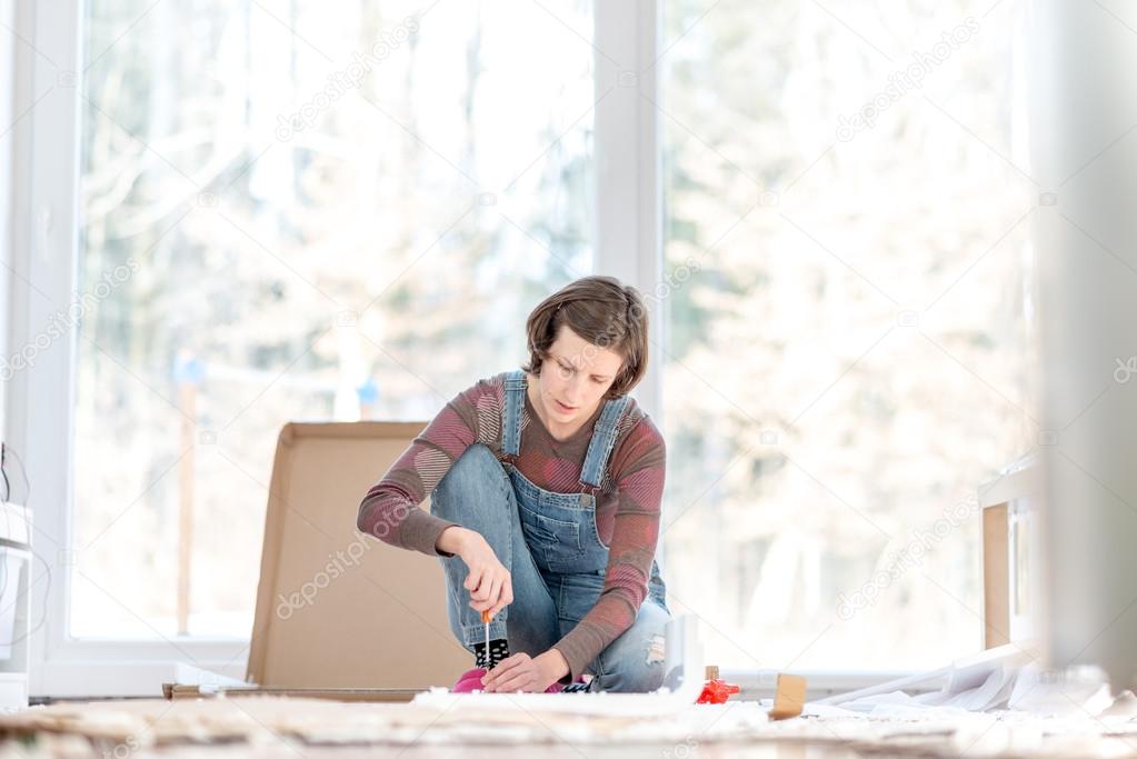 Woman putting togehther home furniture