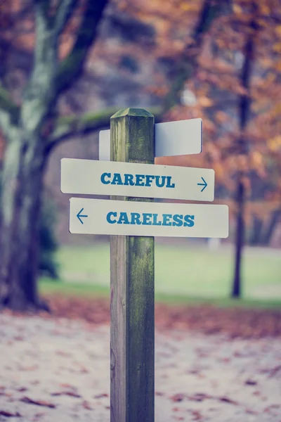 Rustic wooden sign in an autumn park with the words Careful - Ca — Stock Photo, Image