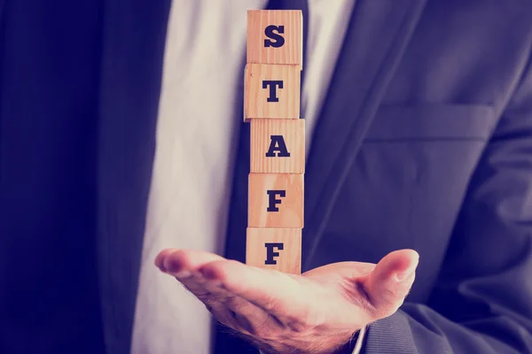 Balancing five wooden cubes spelling the word STAFF — Stock Photo, Image