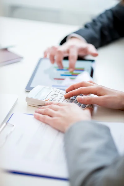 Geschäftskollegen vergleichen Unternehmensstatistiken — Stockfoto