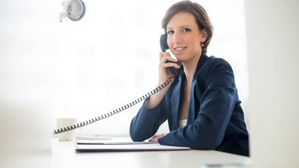 Дружелюбная деловая женщина разговаривает по телефону — стоковое фото