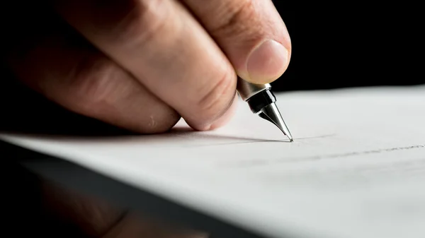 Макро-снимок руки бизнесмена, подписывающего или пишущего документ — стоковое фото