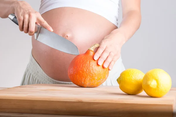 Femme enceinte préparant des légumes dans la cuisine — Photo