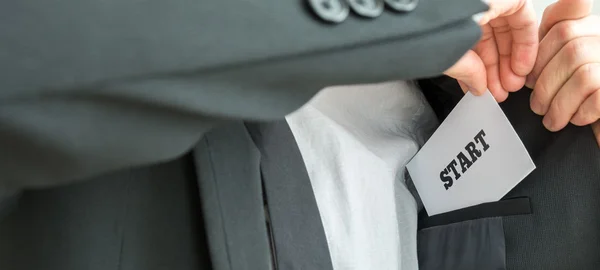 Businessman placing a white card with word Start — Stock Photo, Image