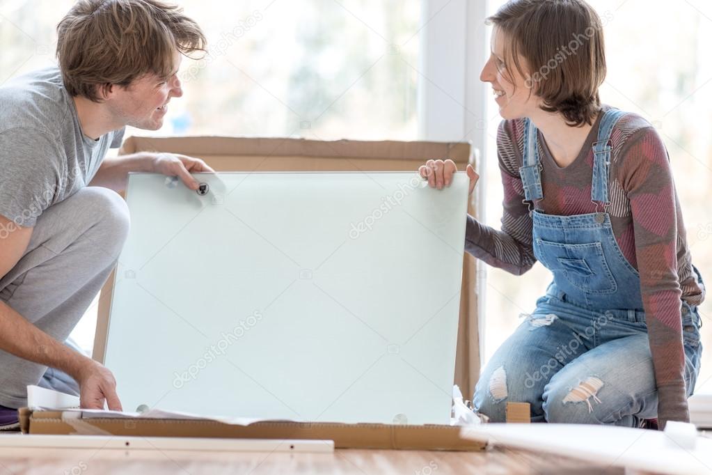 Young couple putting together self assembly furniture
