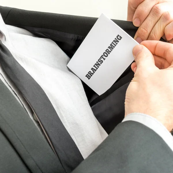 Empresário exibindo uma carta lendo Brainstorming — Fotografia de Stock