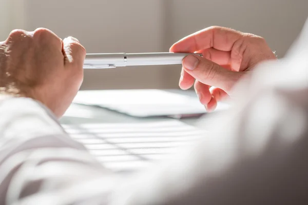 Close up Man Leaning on the Table Holding a Pen — Stock Photo, Image