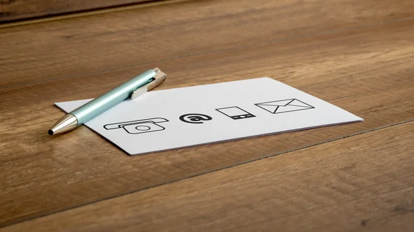 Pen and contact icons printed on a white card — Stock Photo, Image