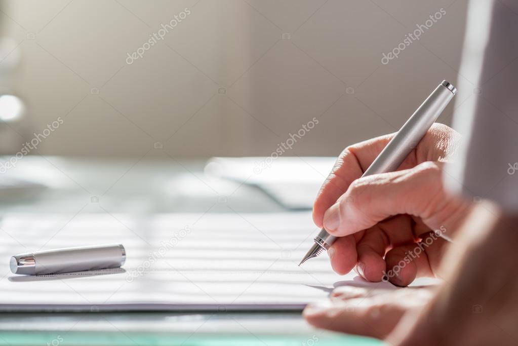 Businessman writing on a document