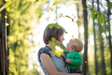 Genç anne bebeğini woodland içinde tutan