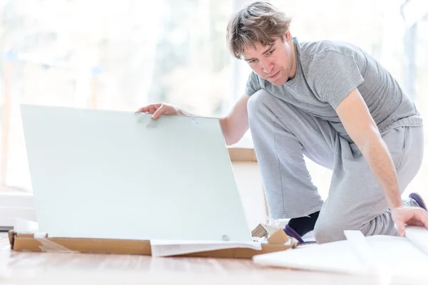 Man unpacking flat pack components — Stock Photo, Image