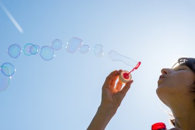kadın bir dere baloncuklar üfleme kutluyor