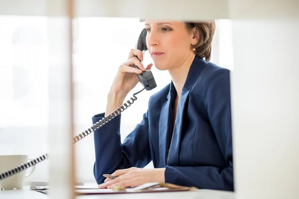 Empresária em sua mesa Respondendo a um telefonema — Fotografia de Stock