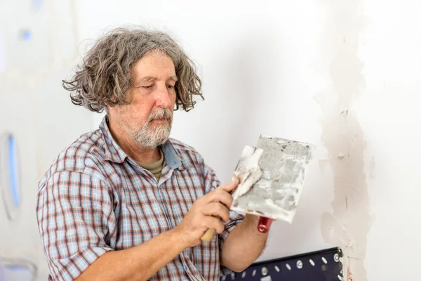 Bouwer of huiseigenaar herstellen een muur — Stockfoto