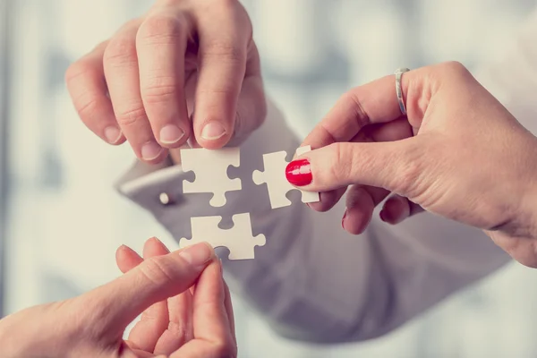 Different people matching three puzzle pieces — Stock Photo, Image