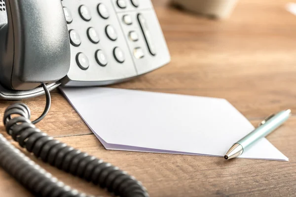 Pero na prázdné bílé Poznámka karty vedle telefonní linka — Stock fotografie