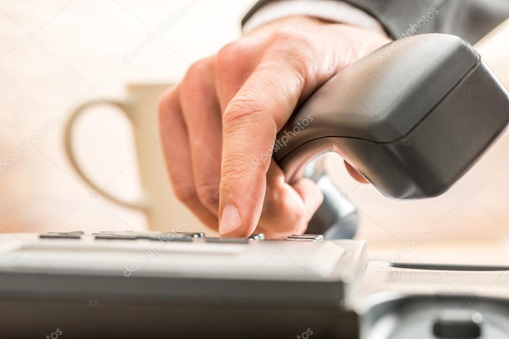 Business adviser dialing out on a land line telephone