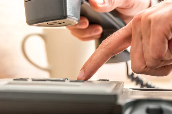 Nära håll pekfingret ringer på svart telefon — Stockfoto