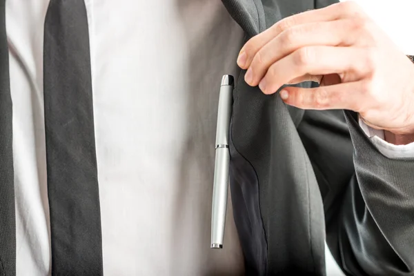 Geschäftsmann hebt seine Jacke beiseite, um an einen Stift zu gelangen — Stockfoto