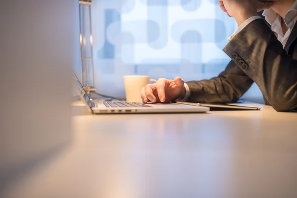 Homme d'affaires utilisant ordinateur portable avec café sur le côté — Photo