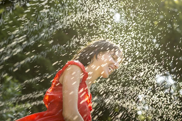 Wanita tertawa mendingin di bawah semprotan air — Stok Foto