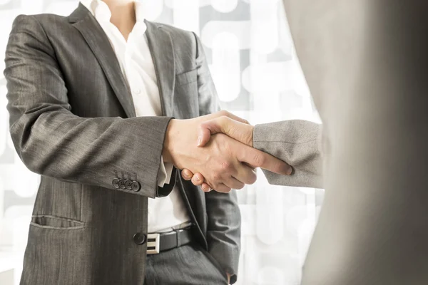 Male and female business or political partners shaking hands in — Stok fotoğraf