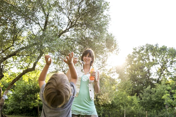 Joven madre jugando con su hijo al aire libre — Foto de Stock