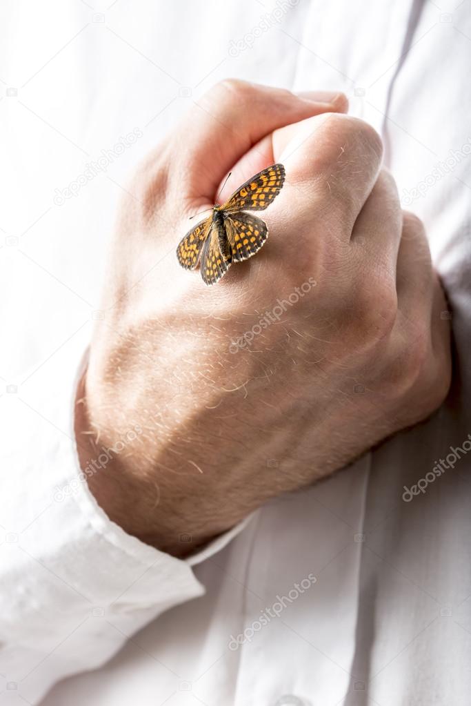 Man with a butterfly on his clenched hand