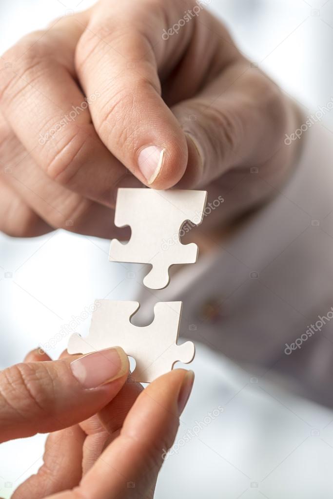Businesspeople fitting together matching interlocking puzzle pie