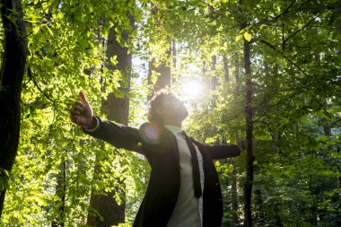 Kollarını ile ayakta işadamı woodland içinde outspread