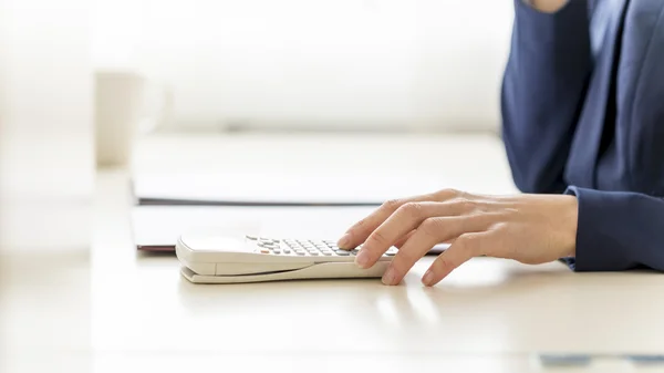 Bookkeeper hand calculating annual expenses and incomes on white — 图库照片