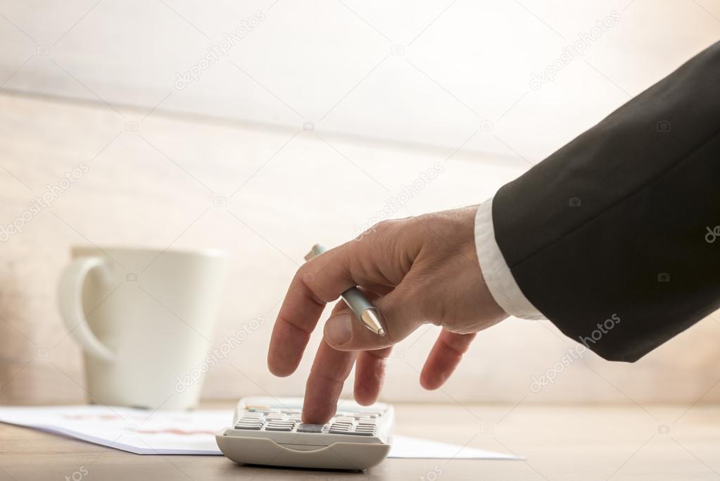 Businessman or accountant doing a calculation on a calculator