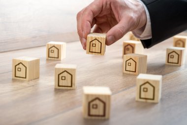 Man Arranging Wooden Cubes with House Drawings