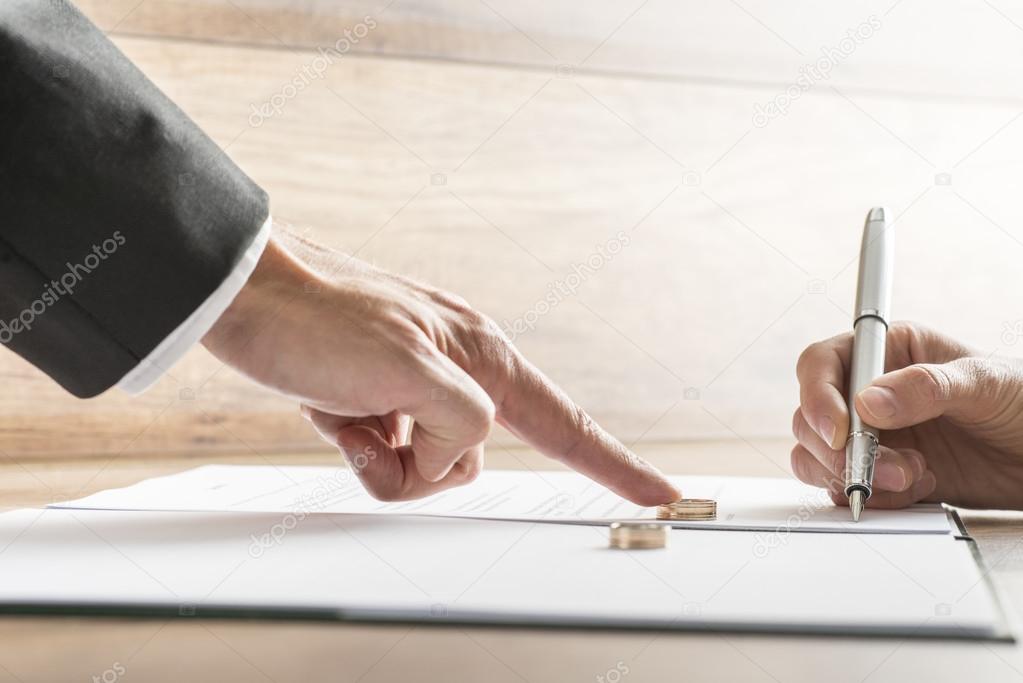 Male hand pushing a wedding ring over to a female hand about to 