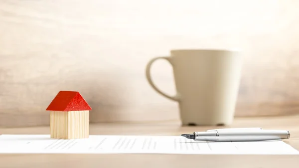 Miniatur, Stift und Vertrag zu Hause auf dem Tisch — Stockfoto