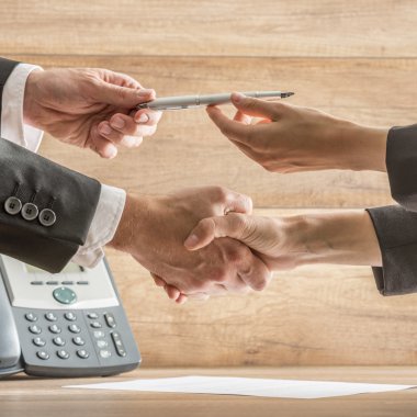 Businessmen Hands Holding Pen While in Handshake