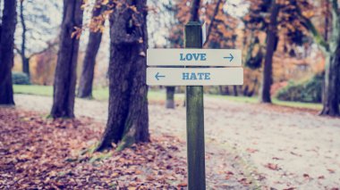 Rustic wooden sign with the words Love - Hate 
