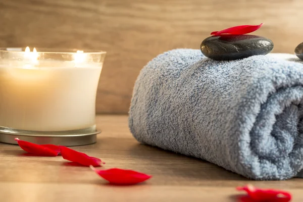 Ambiente de spa luxuoso com uma toalha azul enrolada, vela romântica — Fotografia de Stock