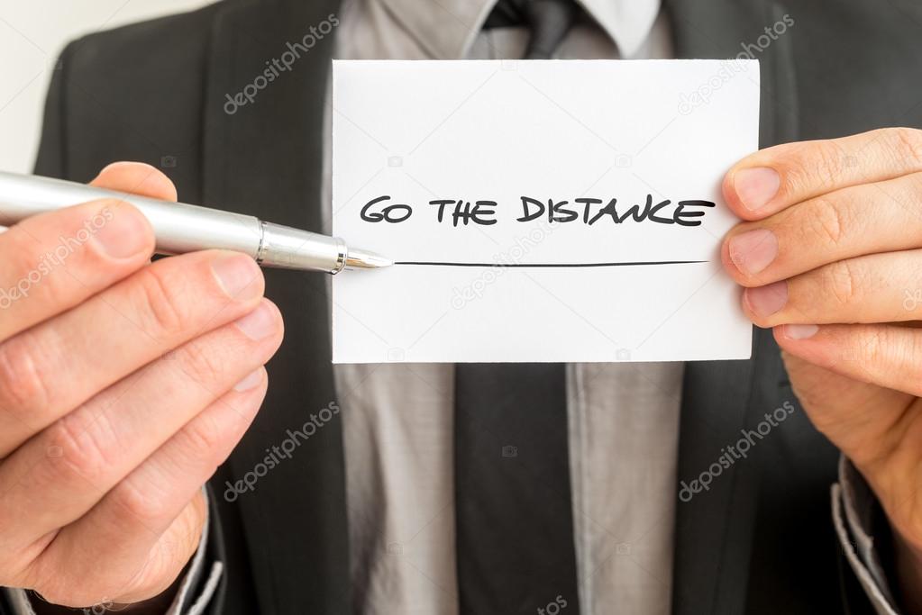 Personal motivator holding up a white card with a Go the distanc