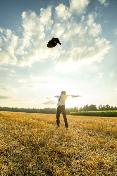 Joven exitoso arrojando su abrigo al aire — Foto de Stock