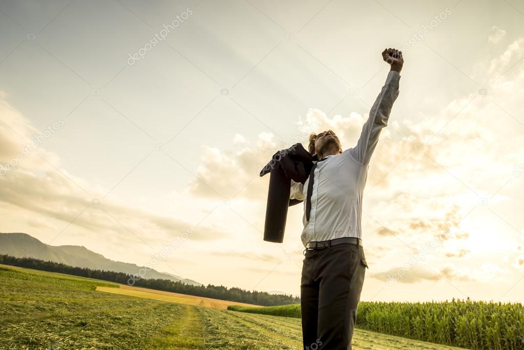 Thankful Man in the Field Raising Arm for Success