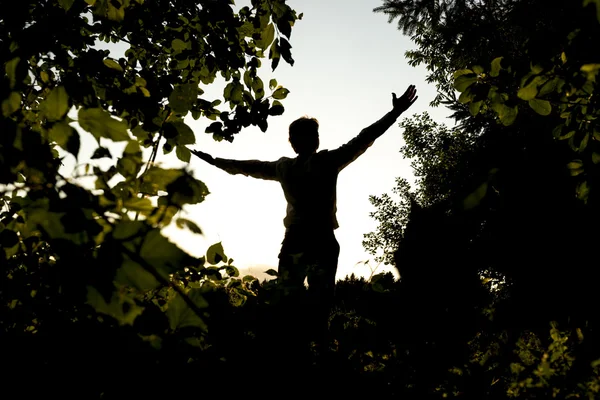 Silhouette Young Man abriendo sus brazos en el campo —  Fotos de Stock