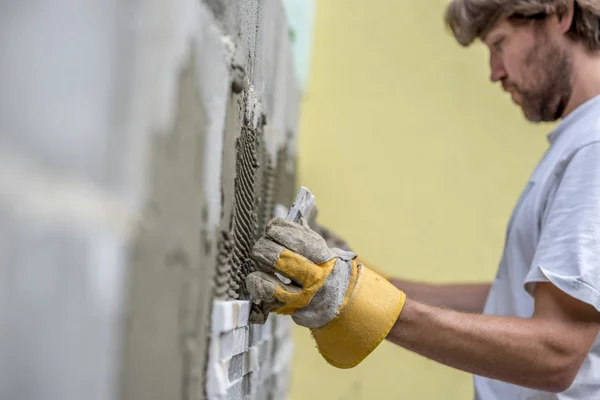 Builder tiling a concrete wall — Stok fotoğraf