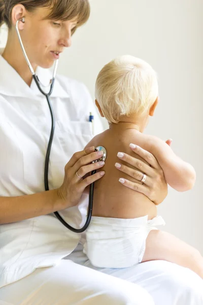 Медсестра-педиатр осматривает ребенка — стоковое фото