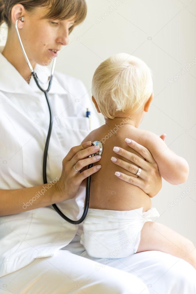 Paediatric nurse examining a baby