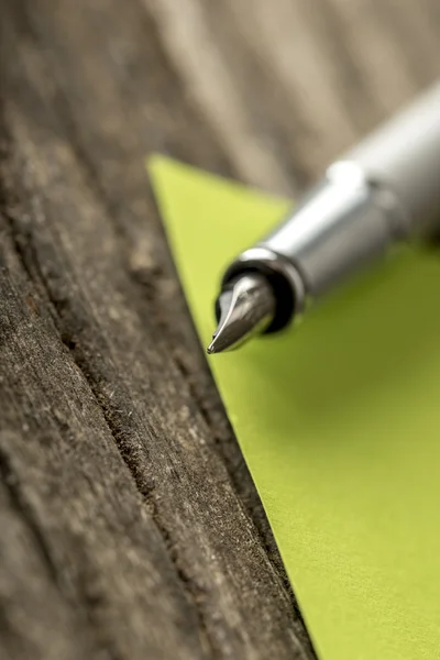 Pluma estilográfica de plata en una nota de papel verde vacía —  Fotos de Stock